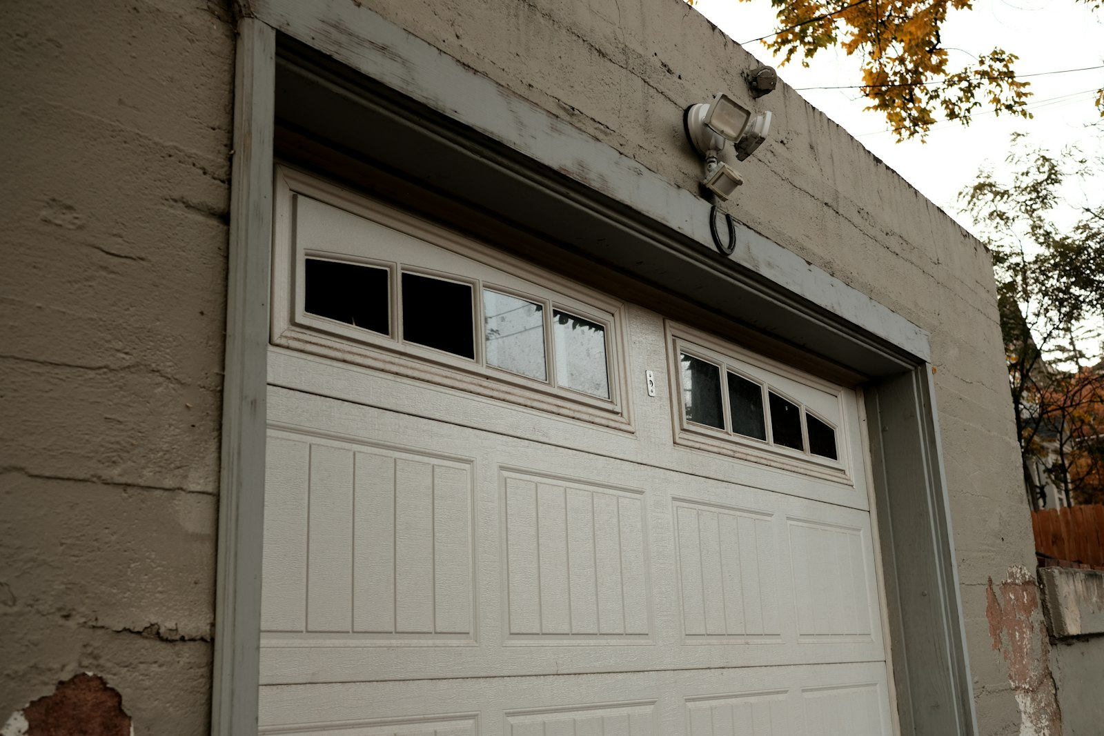 A closed white sectional garage door set in a brick wall